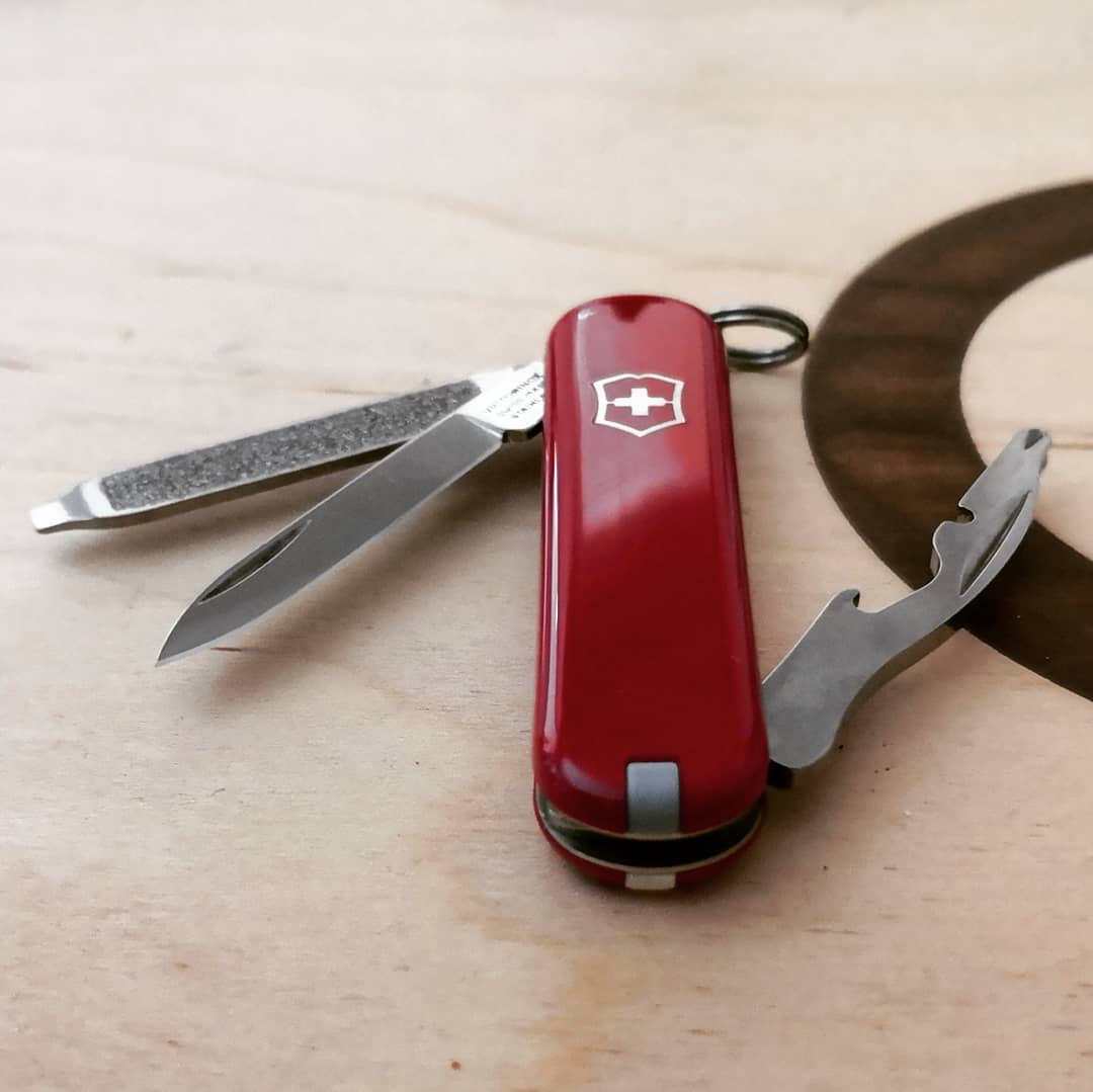 Navaja Victorinox Rally sobre una mesa con sus funciones abiertas